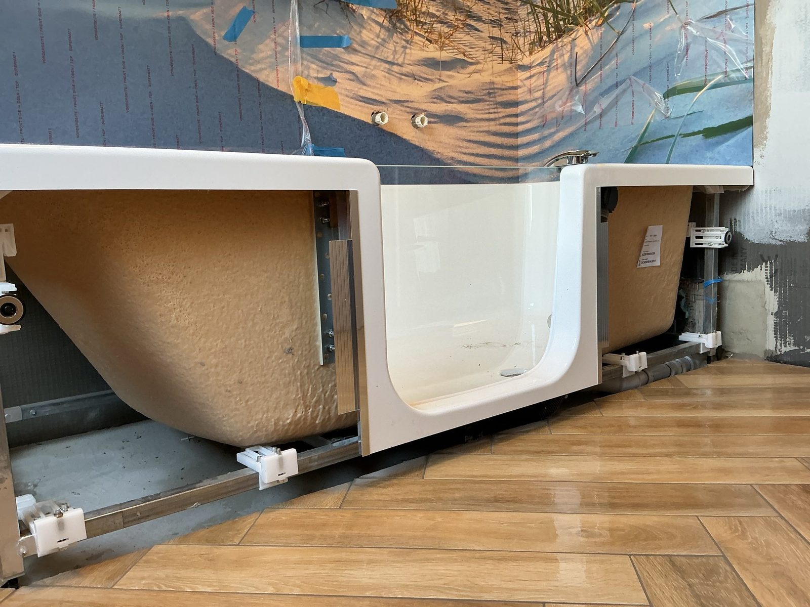Sitzbadewanne mit Tür auf verstellbarem Fußgestell während der Montage